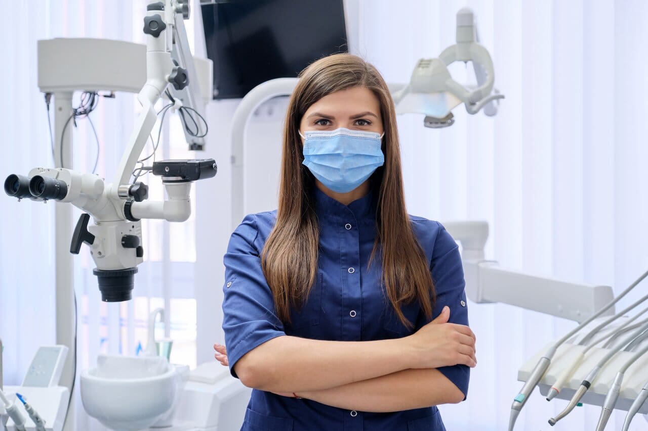 Portrait of young female doctor dentist in medical face mask in dental office - Dental CPA Portrait of young female doctor dentist in medical face mask in dental office