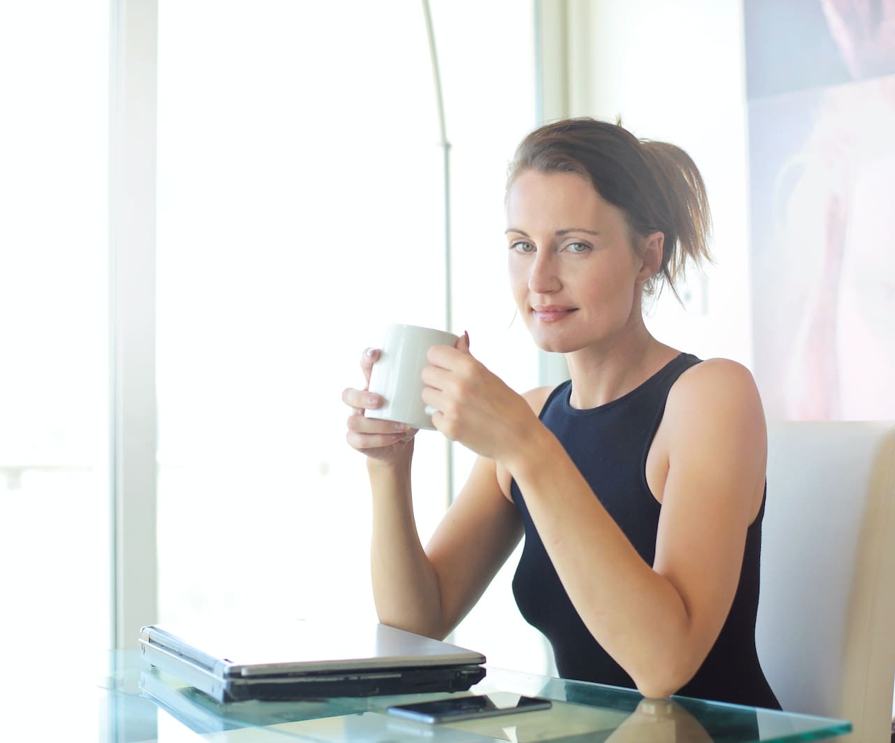 woman holding a cup in her office
