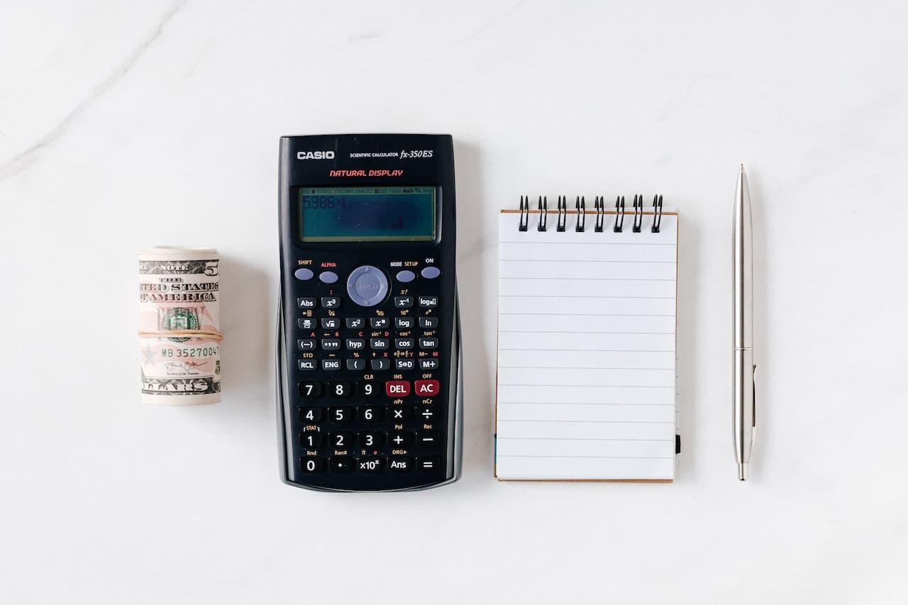 cash, calculator, notepad, and pen